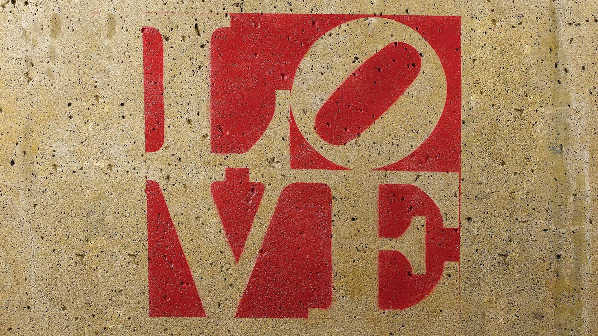 Liefde-inskripsie teken in rooi op 'n betonmuur vir Gelukkige Valentynsdag.