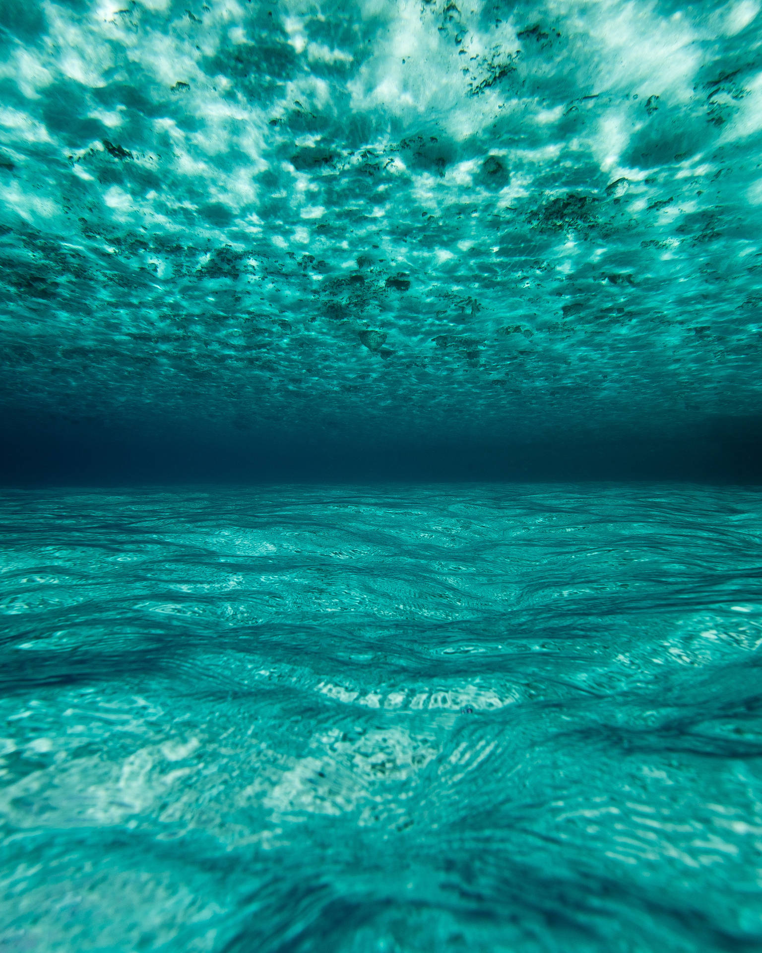 Helder Blou Oseaan in die Maldive, onderwateropname met sonligweerkaatsing op water. — Oseaan Muurpapier