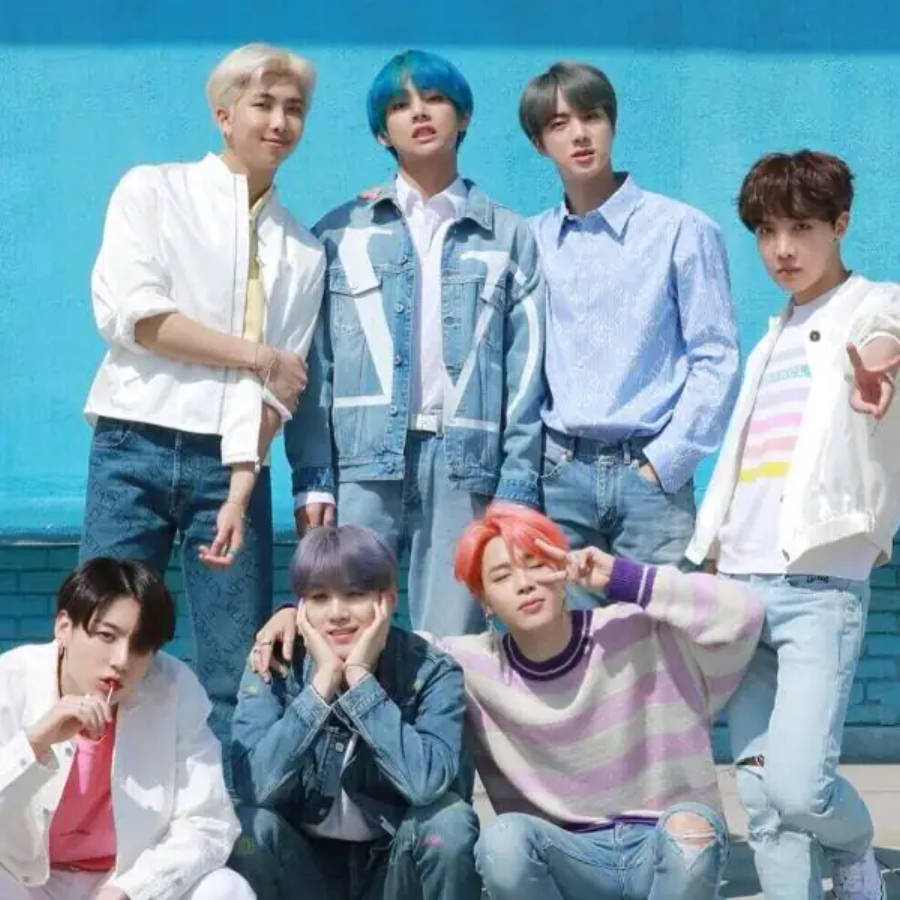 Oulike BTS-groep wat saam poseer teen 'n blou muur Muurpapier