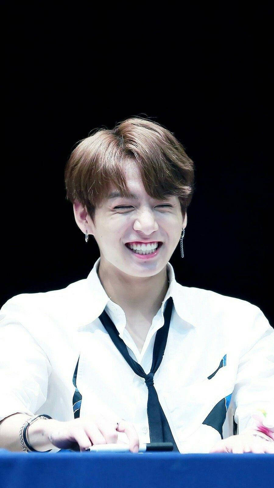 Oulike BTS Jungkook wat glimlag by aanhangersbyeenkoms Muurpapier