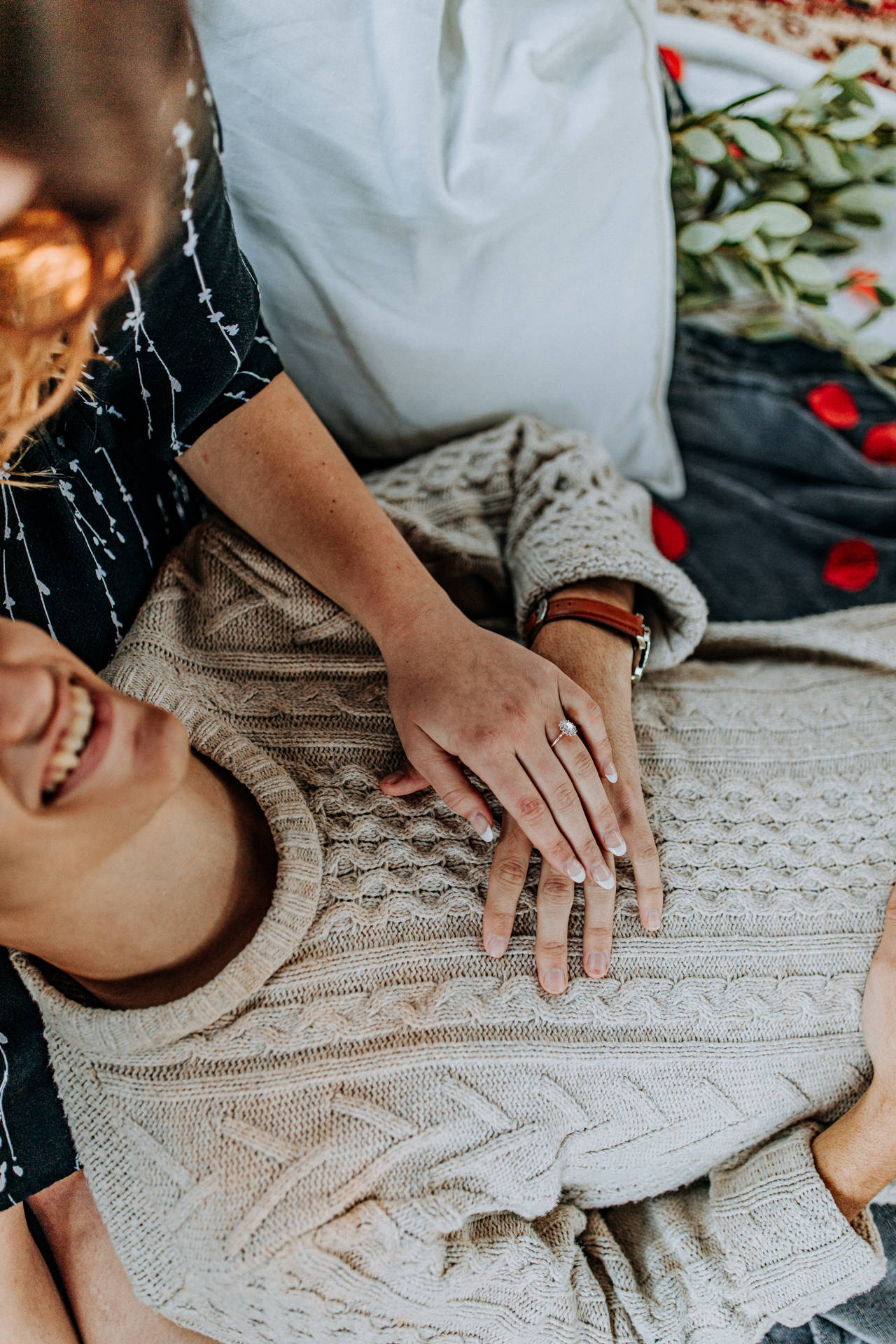 Paartjie in liefde op 'n afspraak met 'n man wat op die meisie se skoot lê terwyl hulle hande vashou. Piekniekafspraak op Valentynsdag.