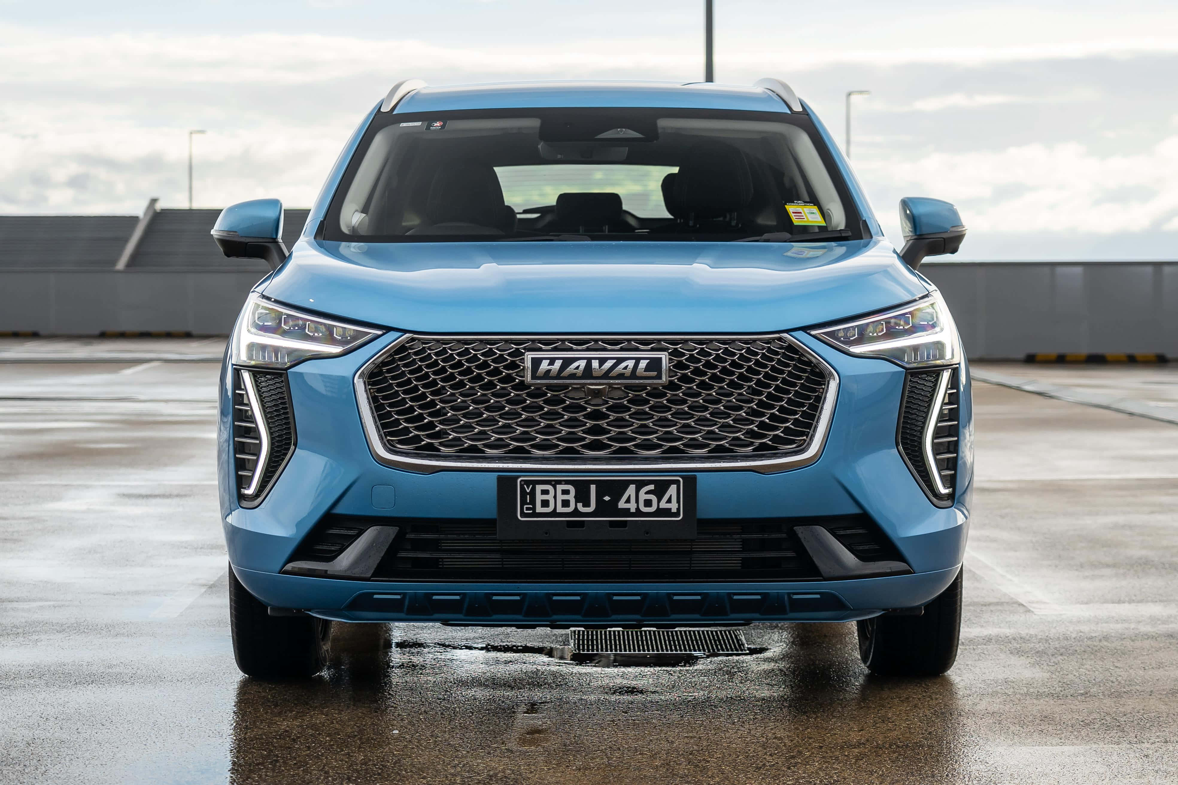 Slanke en moderne Haval SUV wat deur 'n uitgestrekte landskap ry Muurpapier