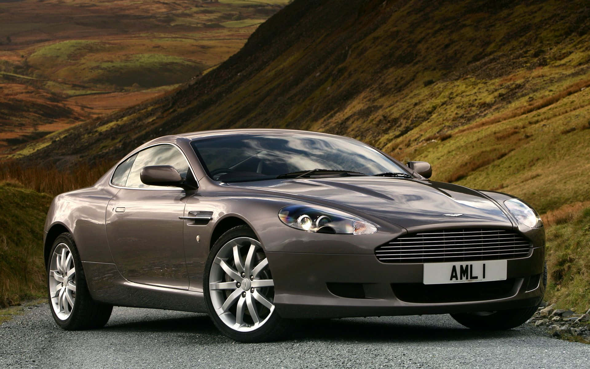 Slinkse Aston Martin DB9 op die Oop Pad Muurpapier