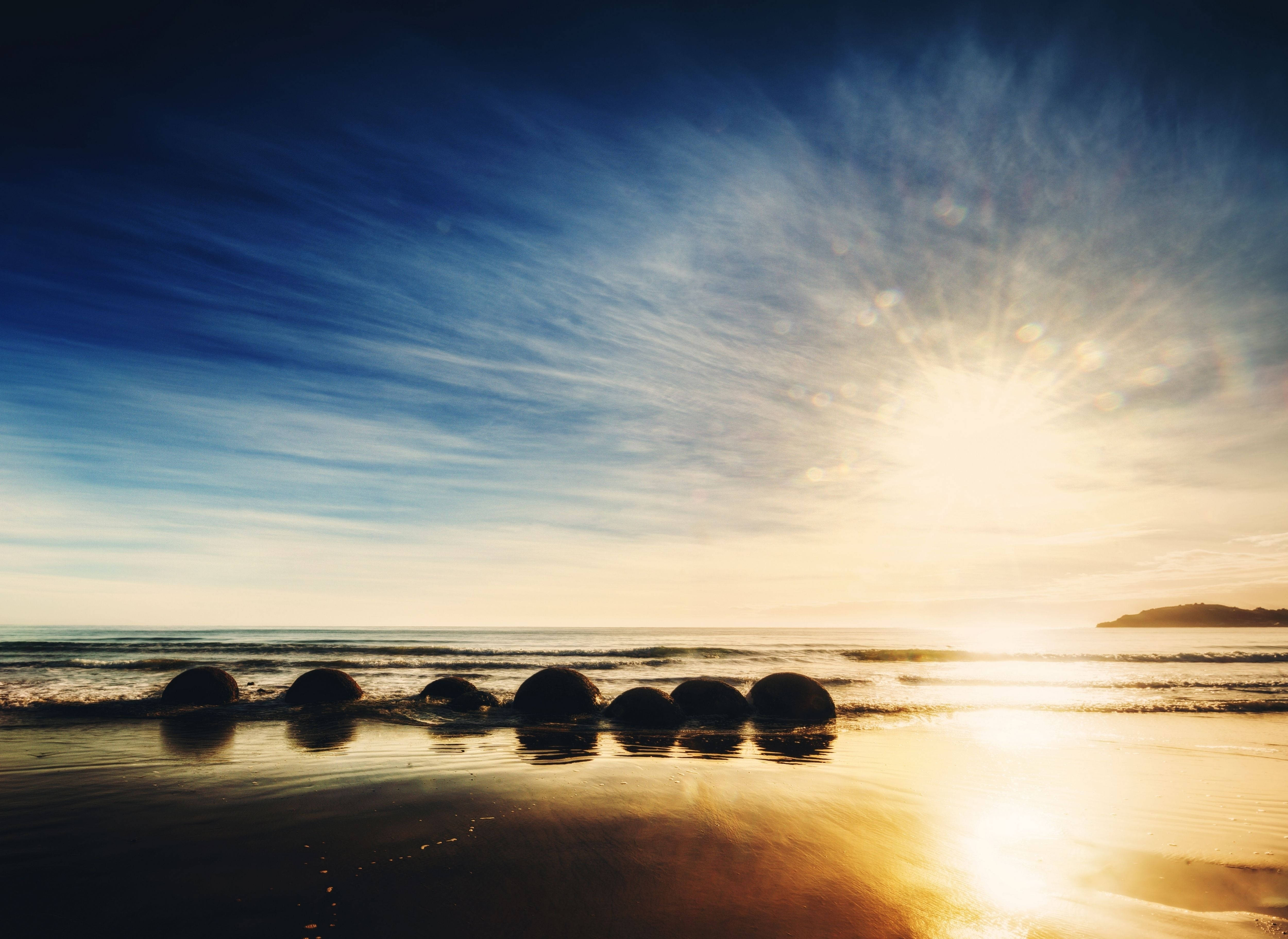Staan op met die son op Moeraki Boulders-strand Muurpapier