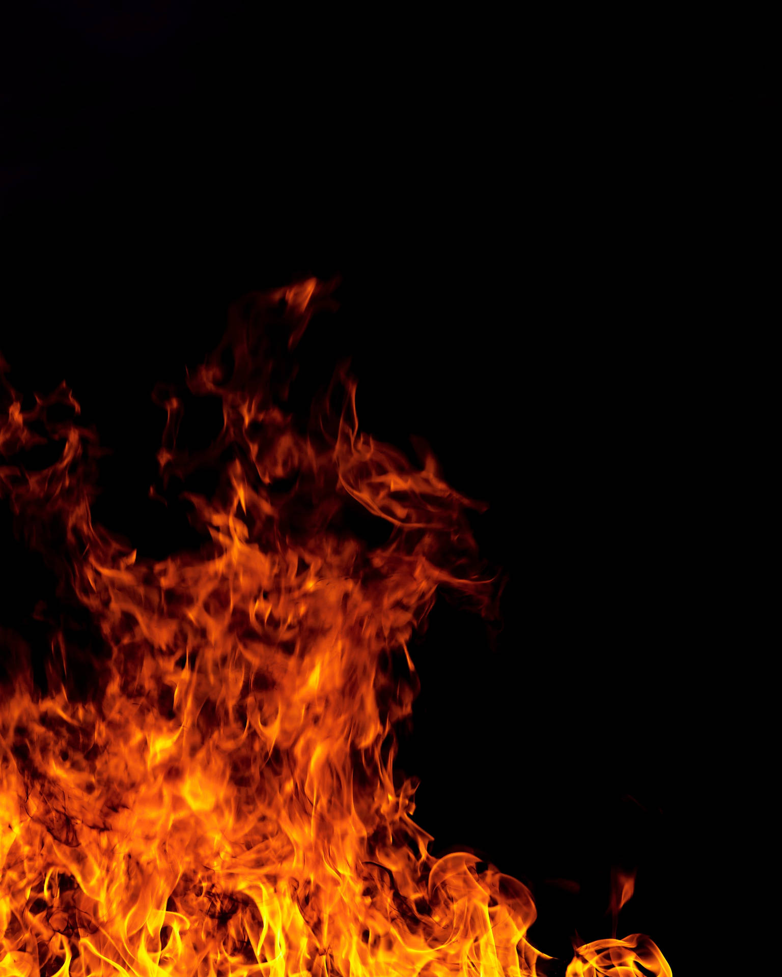 Brandende vuur met rooi en oranje vlamme wat in die donker brand.