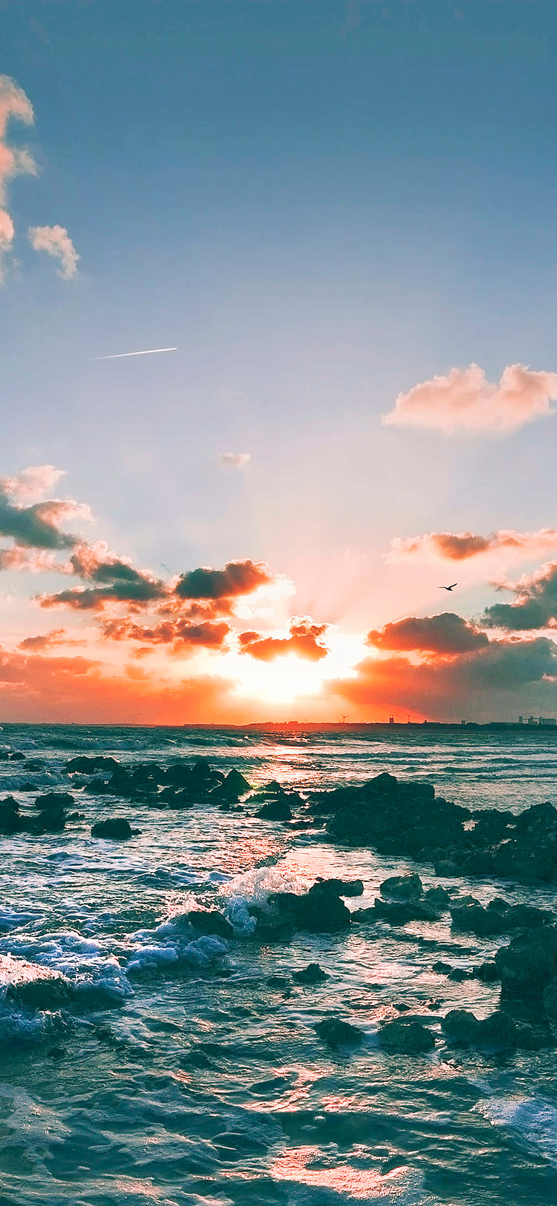 Stralende Sonsondergangwolk oor 'n Rustige Oseaan Muurpapier