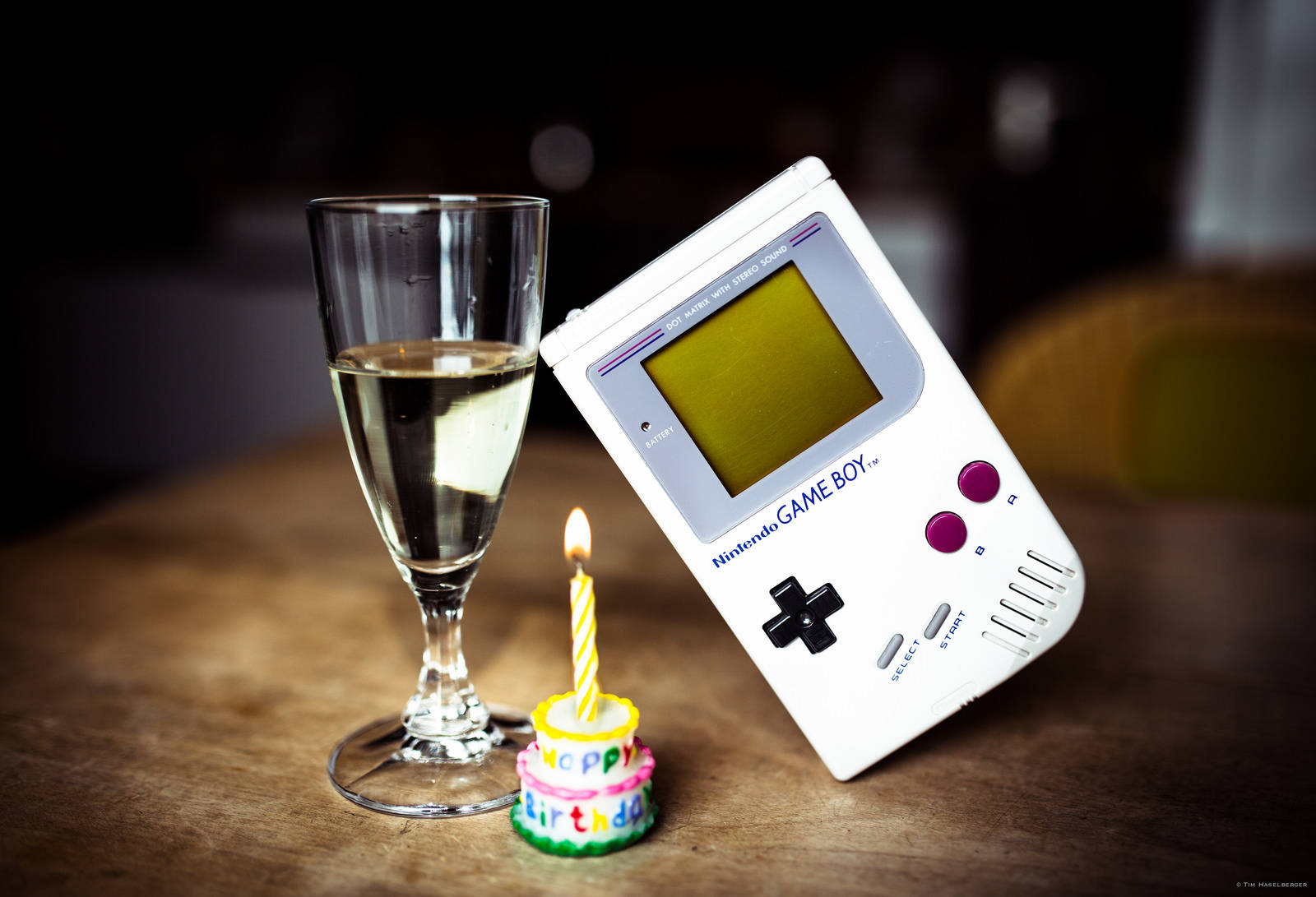 Vintage Game Boy-replika vertoon op glastafel met 'n stukkie koek Muurpapier
