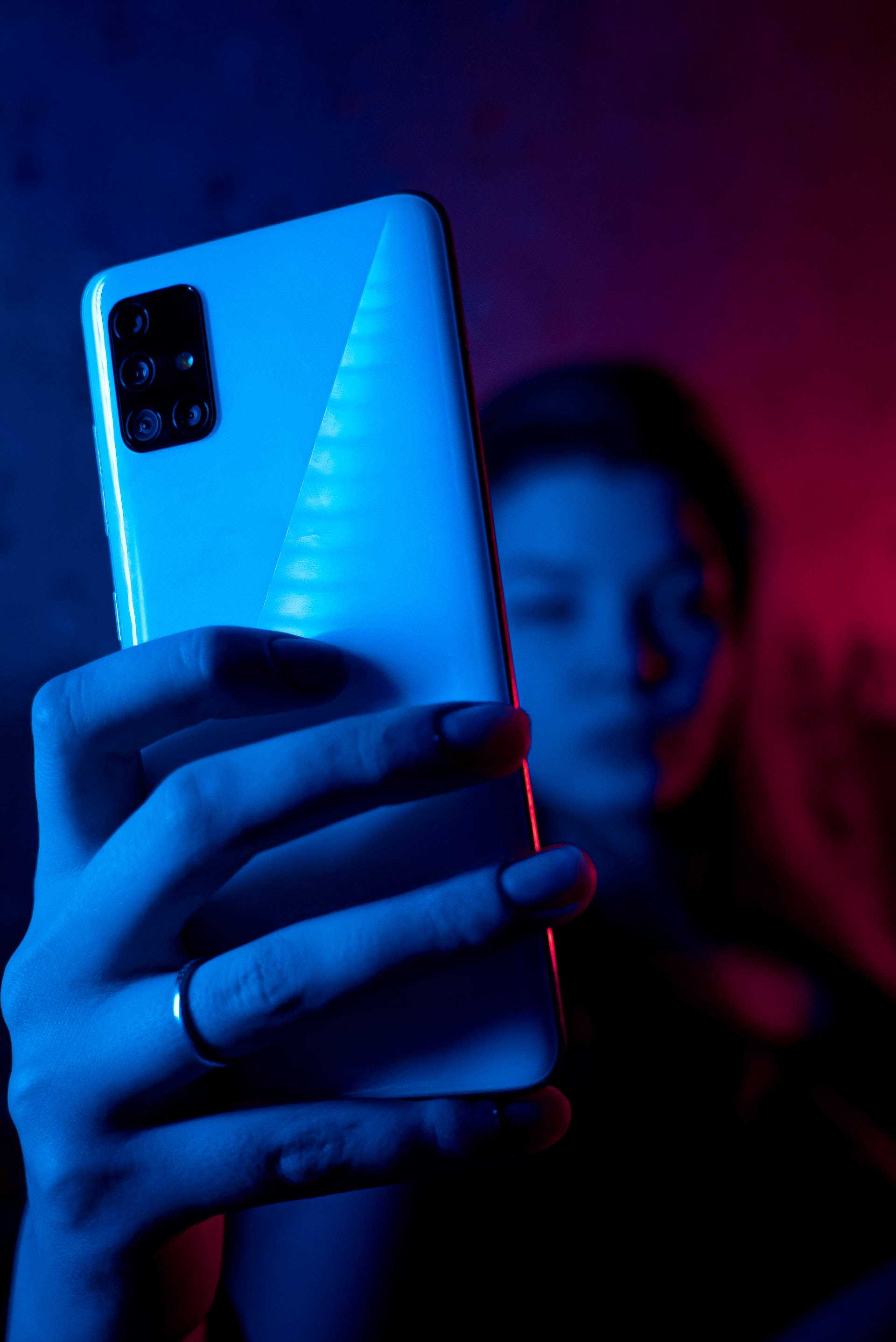 Vrou Met Foon In Neon Blou iPhone Muurpapier