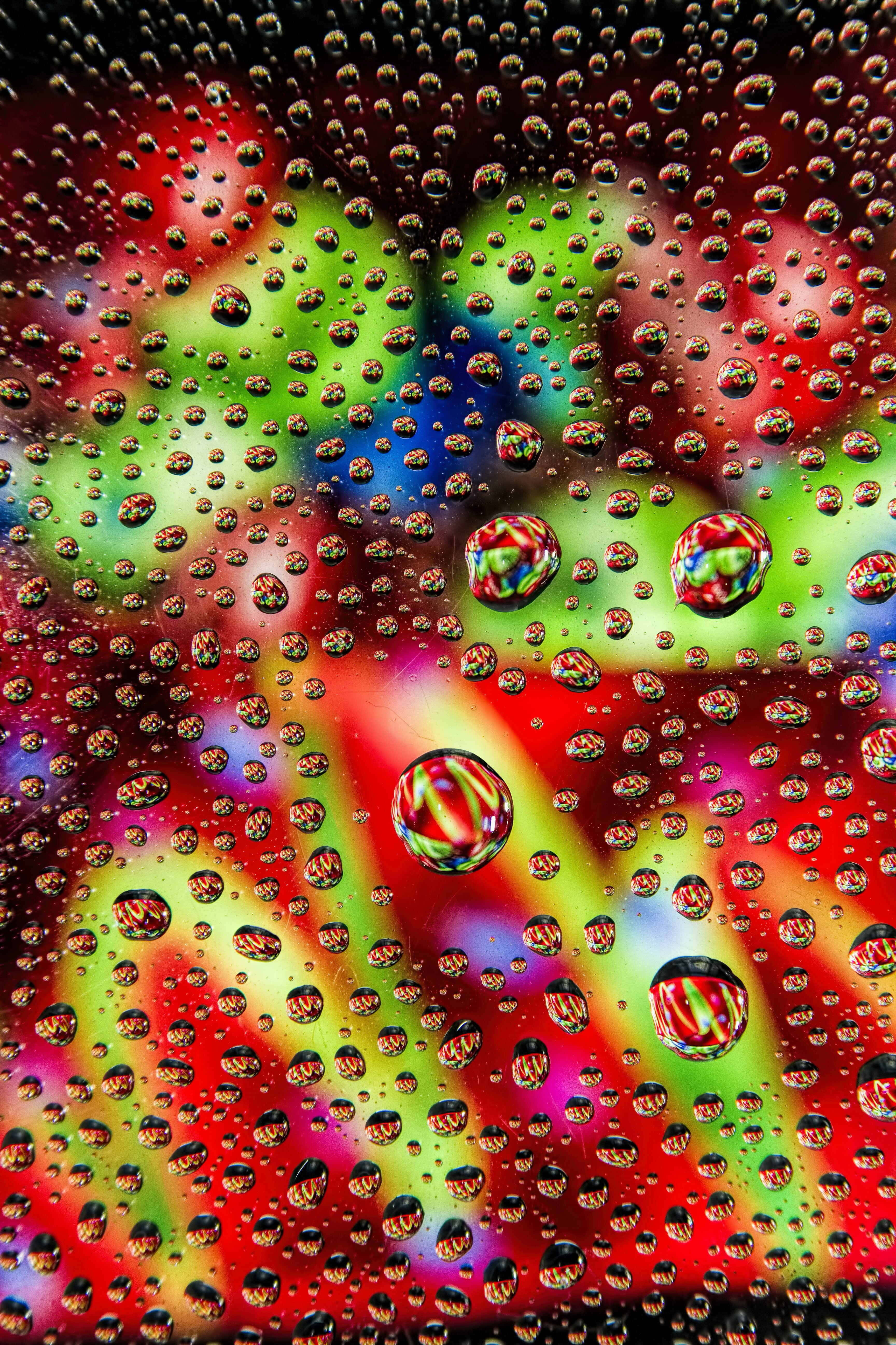 waterdruppels op 'n glas met kleurvolle ligte Muurpapier