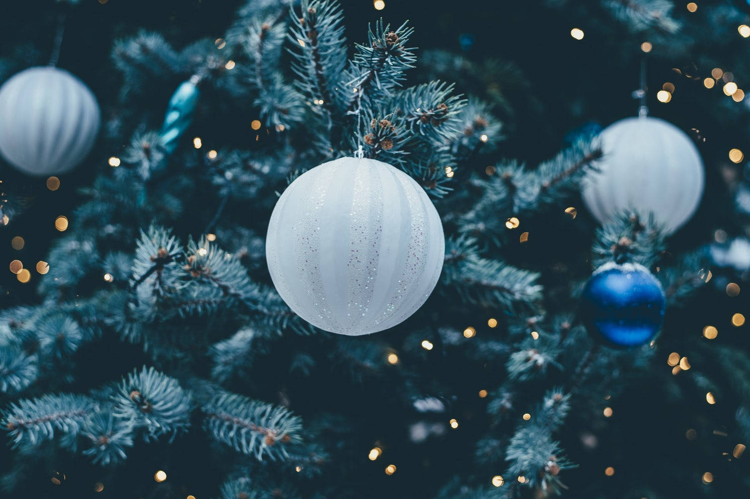 Wit Kersfeesbal op Feestelike Boom Nabyfoto Muurpapier