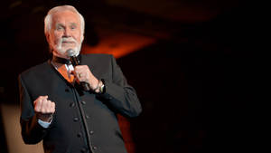 Amerikaanse Beroemde Liedjieskrywer Kenny Rogers — Donkerrooi Muurpapier