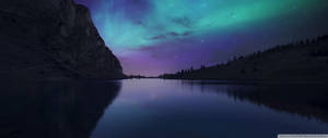 Ultrawye Aurora Borealis kleurvolle pastelblou en pers lug met sterre uitsig vanaf die berge.