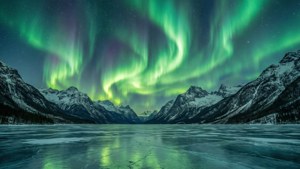 ’n Pragtige groen aurora borealis verlig die naghemel oor sneeubedekte berge. — Groen lug Muurpapier