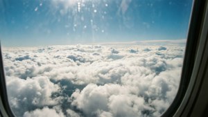 Lugfoto vanuit 'n vliegtuig van blou lug bo en wit wolke onder. — Luguitsig Muurpapier