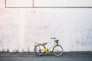 Geel Stadsfiets Naby Wit Muur muurpapier. — Dagbreek Muurpapier