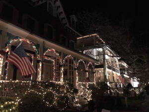 Huis in New Jersey met Kersfeesliggies en Amerikaanse vlag — Gesellige kersfees-estetika Muurpapier