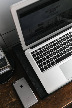 iPhone-bank met silwer MacBook — Xiaomi Pad 7 Ultra Muurpapier