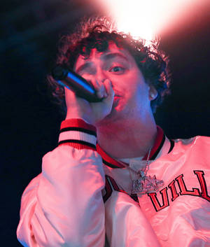 Jack Harlow wat mikrofoon vashou agtergrond — Motorola Razr Ultra 2025 Muurpapier