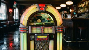 'n Neonverligte jukebox in 'n stemmingsvolle retro-kroeg. — Retro estetika Muurpapier
