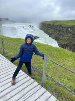 Kind wat Gullfoss-waterval in Suidwes-Ysland besoek — Waterval Muurpapier
