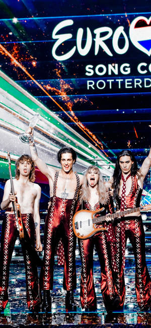 Maneskin staan op verhoog agtergrond — iPhone 16 Muurpapier