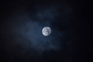 Helder maan wat in die donker lug skyn gedurende middernag. Volmaan bo wat die kraters wys.