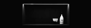 AMOLED-agtergrond van 'n swart rak met wit bottel en glas.