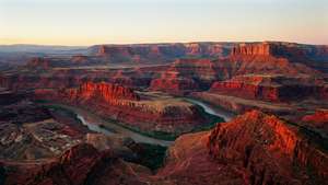 Wye panoramiese uitsig oor die Rooibergreeks teen sononder met 'n rivier.