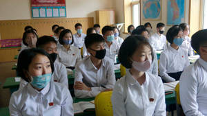Professioneel in Mediese Beskermingstoerusting wat 'n Toetsstel vir Koronavirus Vashou — 16:9 Muurpapier