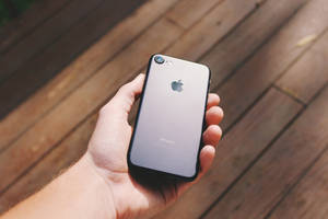 persoon wat 'n swart iPhone 7 vashou — iPhone 8 Muurpapier