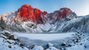 Winterlandskap met rooi berg bedek met sneeu en bevrore meer