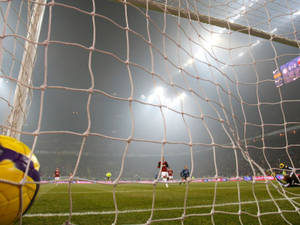 Sokker net doel met spelers in veld agtergrond.
