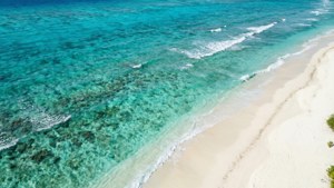 Lugfoto van kristalhelder turkooise see en wit sandstrand. — Oseaan Muurpapier