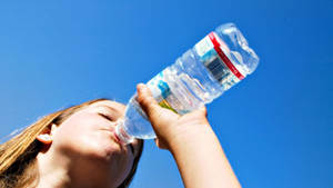 Vrou drink water uit bottel