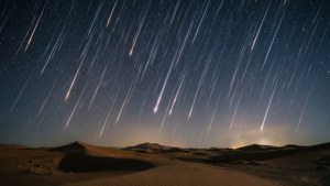 Meteoorreën oor woestynduine onder 'n sterrehemel naghemel. — Luguitsig Muurpapier